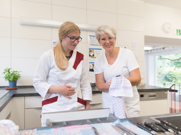 Auszubildende und Ausbilderin polieren Besteck
