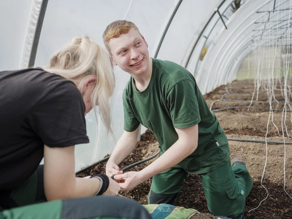 Zwei Auszubildende bei der Gartenarbeit