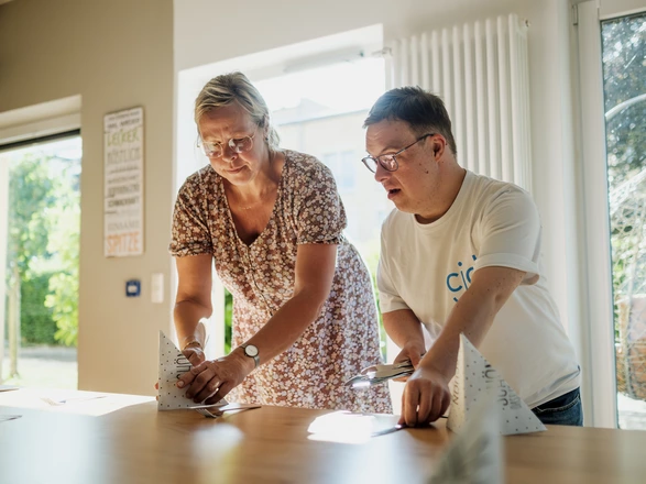 Ausbilderin legt zusammen mit Azubi den Tisch