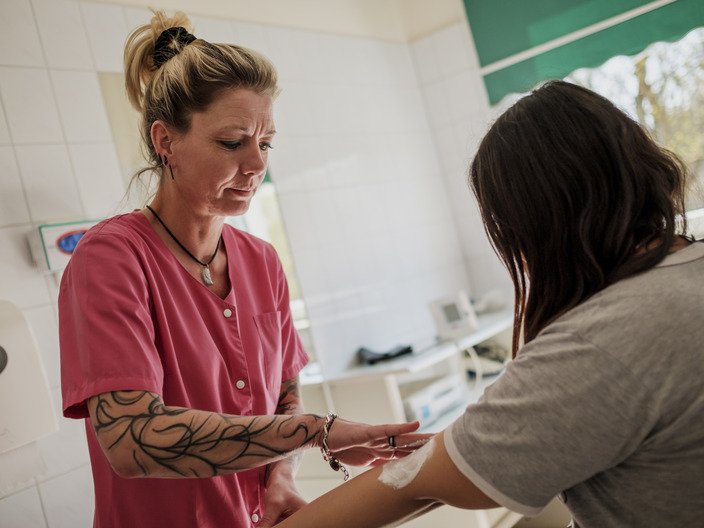Pflegekraft versorgt eine Patientin